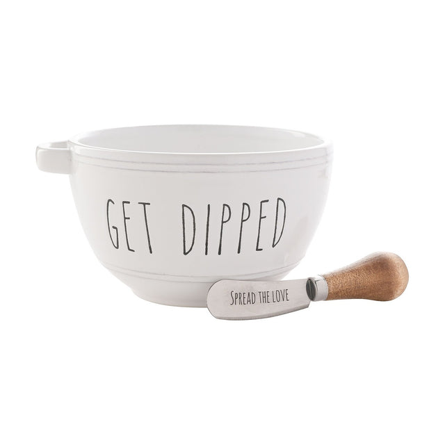 White glazed round stoneware bowl with handle, lettered "GET DIPPED" in black, paired with a wooden-handled spreader reading "SPREAD THE LOVE" on a plain white background.