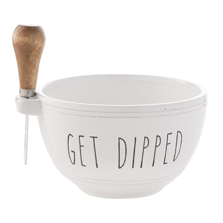 White round glazed stoneware bowl reading "GET DIPPED" with a wooden-handled spreader held in a loop handle at the rim, set on a plain white background.