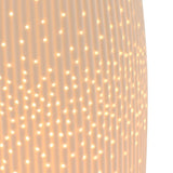 Close-up of the Tall Oval Ribbed Pierced Dot Ceramic Table Lamp in white, showing vertical ribs and illuminated pierced dots glowing from within.