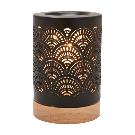 Black ceramic fan lace aroma table lamp with cut-out pattern, top melt dish, and round wood base, lit on a plain white background.