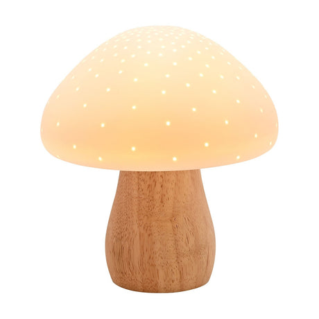 Pierced mushroom ceramic table lamp with a glowing white, pin-pricked cap and curved natural wood-tone stem base, shown lit against a plain white background.