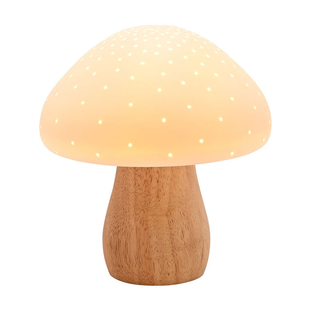 Pierced mushroom ceramic table lamp with a glowing white, pin-pricked cap and curved natural wood-tone stem base, shown lit against a plain white background.