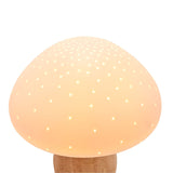 Pierced Mushroom ceramic table lamp with a rounded white dome pierced with small glowing holes, set on a natural wood stem, shown against a plain white background.