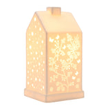 White ceramic house-shaped table lamp, 20.5cm, with pitched roof, chimney, and cut-out butterfly, floral, and star patterns glowing when lit, on a plain white background.