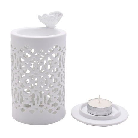 White round ceramic wax melt burner with cut-out lattice pattern and a butterfly on the rim, shown with a round white tealight holder and tealight candle on a plain background.