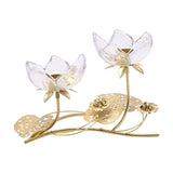 Two-stem flower glass candle holder with clear glass petals on gold stems, gold tealight cups, and pierced gold leaves, shown on a plain white background.
