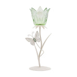 Single stem glass candle holder shaped like a tulip, with a pale green crown-edged cup, white metal stem, leaves, and a butterfly detail on a round base.