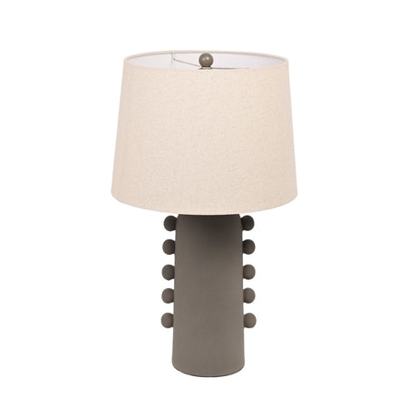 Beaded ceramic table lamp with a tall grey column base featuring raised bead rows on either side, topped with a tapered oatmeal fabric shade, on a plain white background.