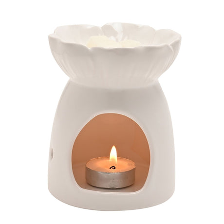 White ceramic wax melt burner shaped like an open flower, with a scalloped petal dish, rounded body, and an arched front opening showing a lit tealight inside.