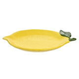 Textured lemon-shaped earthenware plate in yellow with dimpled peel-like surface and a sculpted green leaf at the stalk end, shown on a plain white background.
