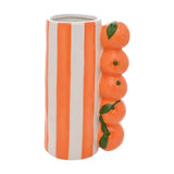 Ceramic vase with bold orange and white vertical stripes, featuring a stacked column of five glazed citrus fruits with green leaves on one side, shown on a plain white background.