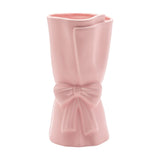 Pink ceramic vase styled as a wrapped bouquet with a folded edge and a ribbon bow at the centre, matt finish, 24cm tall, on a plain white background.
