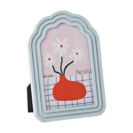 Scalloped arched wooden photo frame in pale blue with stepped tiered layers, holding a 6 x 4in portrait photo, shown at an angle against a plain white background.
