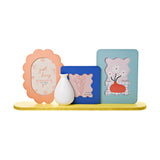 Wooden 3-aperture collage photo frame with vase, featuring coral scalloped oval, cobalt blue wavy-edge square, and aqua rounded frames on a yellow base with white vase.