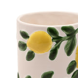 Close-up of the Raised Lemons and Green Leaves Ceramic Mug in white, showing raised yellow lemons and green leafy sprigs in relief against a plain background.