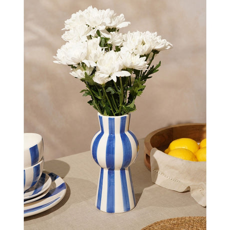 Striped Tall Ceramic Vase with Rounded Middle in blue and white, holding white chrysanthemums, styled on a table with bowls and a lemon-filled bowl.