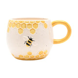 Earthenware mug in cream with raised yellow honeycomb bands and a relief bee design, featuring a yellow loop handle, shown on a plain white background.