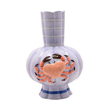Ceramic vase in periwinkle blue with a ribbed, lobed body and fluted, striped neck with scalloped rim, featuring a raised hand-painted orange crab, on a white background.