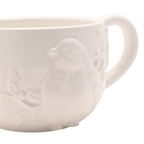 Close-up of the Floral Bird Earthenware Teacup, white ceramic with a raised bird and berry foliage design in relief, curved handle visible, plain background.