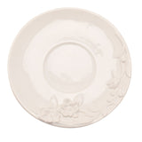 White earthenware saucer from the Floral Bird Teacup & Saucer Set, round with a raised floral and foliage design along one edge, shown on a plain white background.