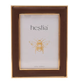 Freestanding rectangular photo frame with textured brown surround and gold-coloured edging, plastic construction, shown on a plain white background holding a sample 5x7in insert.