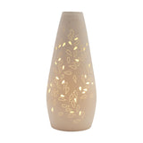 White tapered ceramic table lamp with pierced leaf and vine cutwork that glows when lit, smooth white finish, narrow neck and wider base, shown on a plain white background.