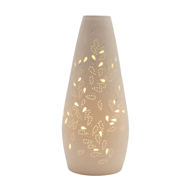 White tapered ceramic table lamp with pierced leaf and vine cutwork that glows when lit, smooth white finish, narrow neck and wider base, shown on a plain white background.
