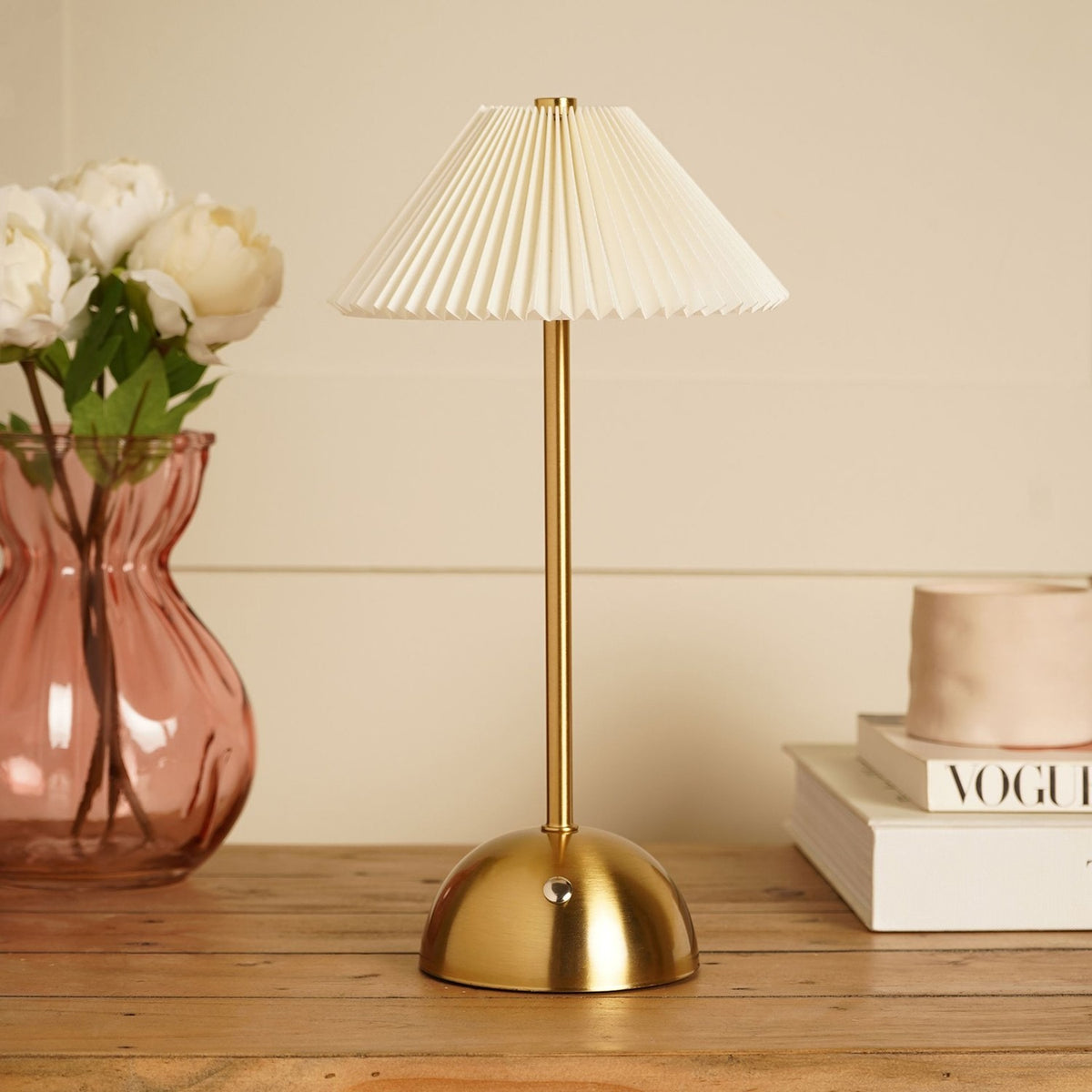Pleated Shade USB LED Touch Table Lamp in bronze and cream, with a dome base and touch sensor on the stem, styled on a wooden table beside a vase of flowers and books.