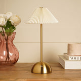 Pleated Shade USB LED Touch Table Lamp in bronze and cream, with a dome base and touch sensor on the stem, styled on a wooden table beside a vase of flowers and books.