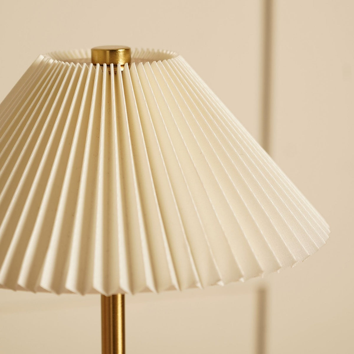 Close-up of the Pleated Shade USB LED Touch Table Lamp, showing cream fine pleats and a brushed bronze stem against a plain light background.