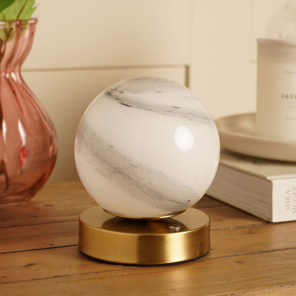 Marbled Glass Ball USB LED Touch Table Lamp with round white and grey swirled glass globe on a bronze-toned base, shown on a wooden surface beside books and a vase.