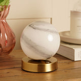 Marbled Glass Ball USB LED Touch Table Lamp with round white and grey swirled glass globe on a bronze-toned base, shown on a wooden surface beside books and a vase.