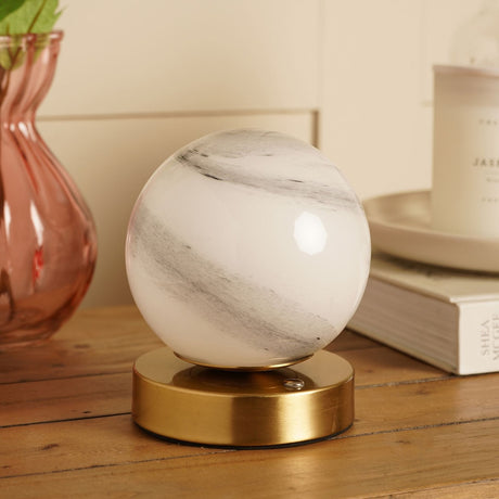 Marbled Glass Ball USB LED Touch Table Lamp with round white and grey swirled glass globe on a bronze-toned base, shown on a wooden surface beside books and a vase.