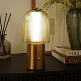 Ribbed Dome USB LED Touch Table Lamp in bronze and champagne, lit on a dark sideboard with a touch button on the cylindrical base, styled beside books and a vase.