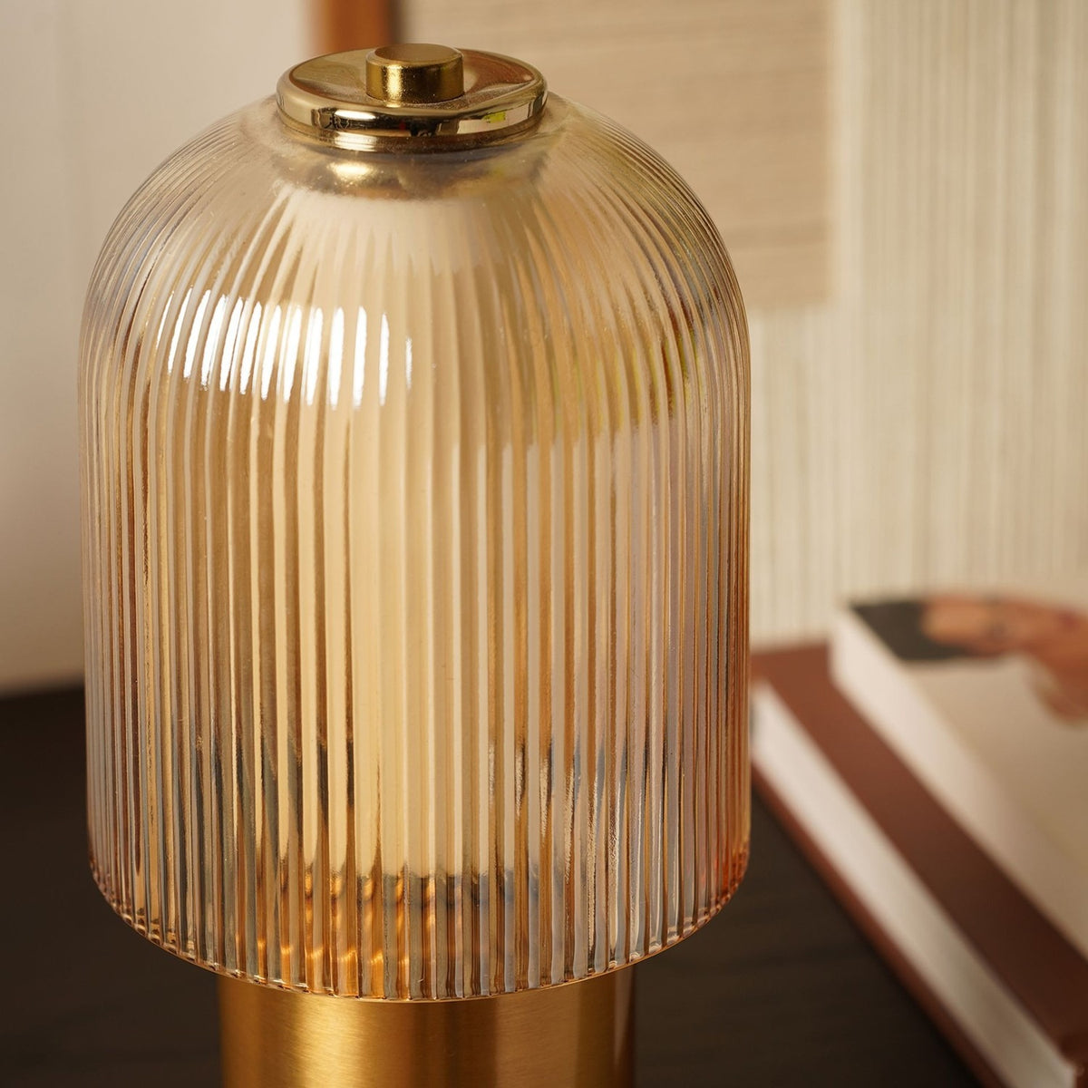 Ribbed Dome USB LED Touch Table Lamp with champagne glass shade and brushed bronze base, shown close-up on a dark surface near books.