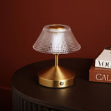 Small Diamond Etched Glass Bronze USB LED Touch Table Lamp with a wide faceted glass shade on a brass-toned base, shown on a dark table beside stacked books.