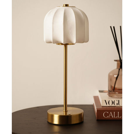 Ribbed Soft Touch Shaded USB LED Table Lamp with a scalloped white dome shade on a slim bronze stem and round base, shown on a dark table beside books.
