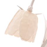 Close-up of the Floral Bell Shade Battery LED Table Lamp, showing the cream bell-shaped flower shade with scalloped petal edges and slender white leaf details against a plain white background.