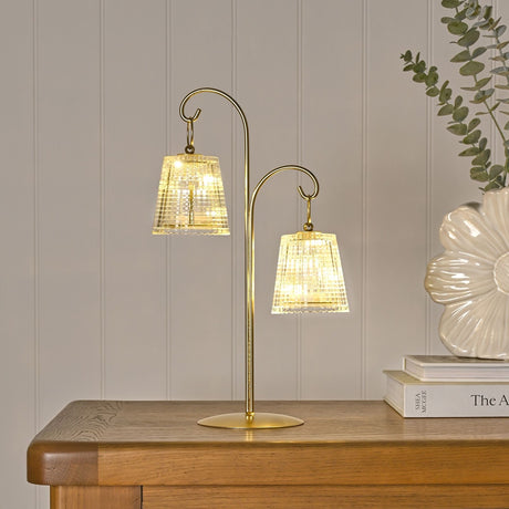 Hanging Shade Double LED Table Lamp 39.9cm in gold, with two clear ribbed shades on curved arms of differing heights, shown on a wooden sideboard.
