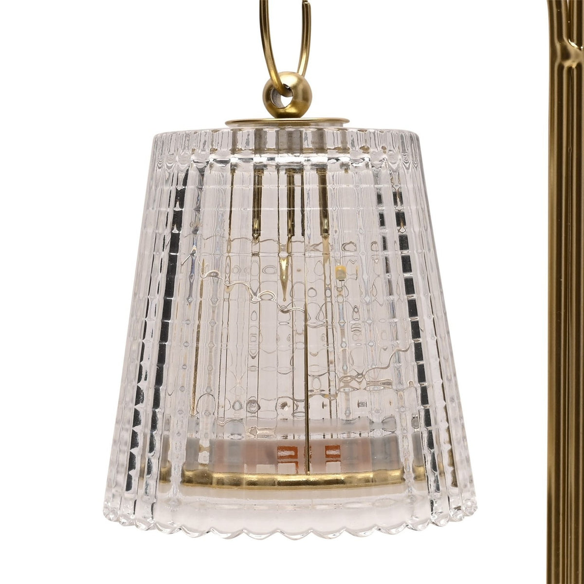Close-up of a clear ribbed glass tapered shade hanging from a gold curled arm on this double LED table lamp, gold and clear finish.