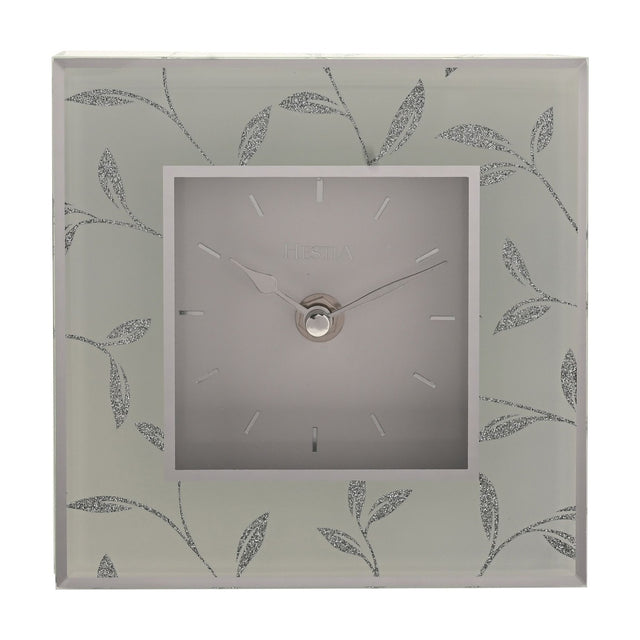 Square mantel clock with a grey square dial, baton markers, and silver hands, framed by a glitter leaf motif on a glass-effect grey border.