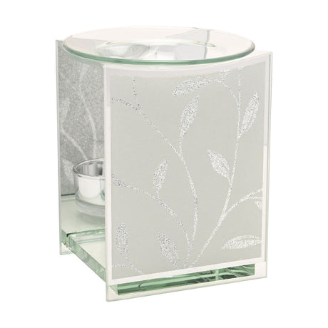 Rectangular glass wax melt burner with a white frosted panel featuring a silver glitter leaf and vine design, mirrored sides, a tealight holder, and a clear glass dish on top.