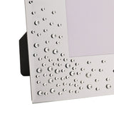 Close-up of a silver glass photo frame with a bevelled edge, clear diamantes clustered in the corner and scattered along the border, with a built-in easel stand.