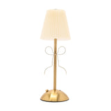 Brass Bow Pleated LED Touch Table Lamp with cream pleated shade, slim gold stem, and metal ribbon bow detail, on a dome base against a plain white background.