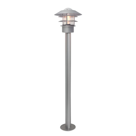 The Helsingor 1 Light Bollard Lantern in silver showcases Scandinavian design with its modern aesthetics, featuring a round, tiered lampshade and a visible light bulb. It's mounted on a sturdy cylindrical base, making it an ideal outdoor lighting fixture.