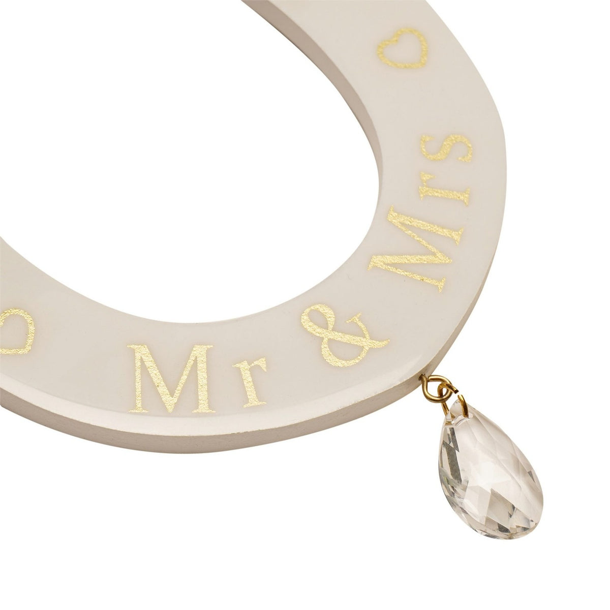 Close-up of cream MDF horseshoe wall art with gold "Mr & Mrs" lettering, outline hearts, and a faceted clear teardrop charm on a gold ring, shown against a white background.