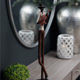 Hill Interiors Nerisse Standing Jazz Violinist Figurine in bronze resin, displayed on a wooden sideboard beside a round mirror and lattice lantern.