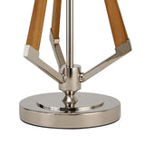 Close-up of the Hilton 1 Light Wood Table Lamp in nickel and taupe, featuring a sleek, reflective circular base with wooden tripod legs and metal fittings—an elegant wood table lamp with a modern, clean-line design. Shade not included.
