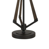 The image shows the lower part of the Hilton 1 Light Large Wood Table Lamp, featuring a circular black base with three angled dark wooden supports and a stylish black and grey finish.