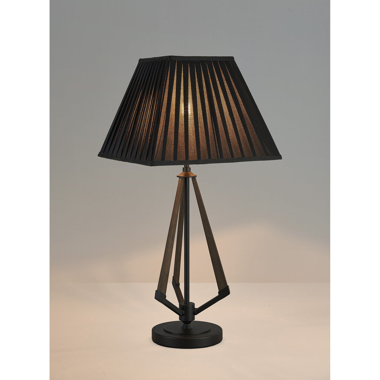 The Hilton 1 Light Large Wood Table Lamp features a black and grey base with a black shade, casting a warm glow on a light surface and standing out elegantly against a plain background.